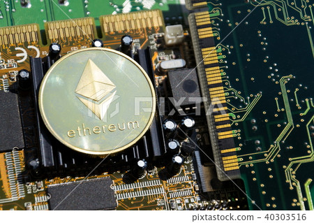 Golden ethereum coin lying on computer motherboard Golden ethereum coin lying on computer motherboard 40303516