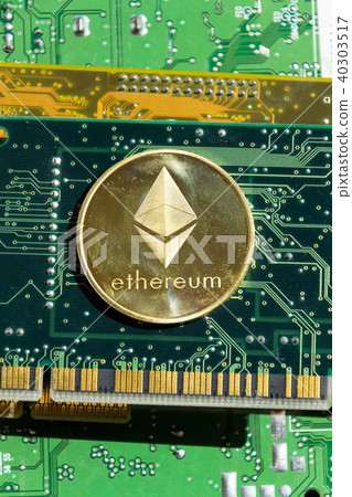 Golden ethereum coin lying on computer motherboard Golden ethereum coin lying on computer motherboard 40303517