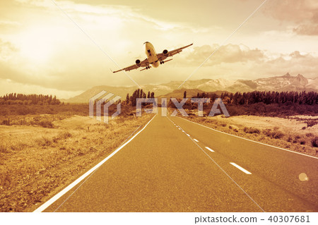 Airplane flying over roadway 40307681