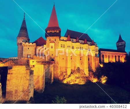 Corvin Castle is on the green mountain in night 40308412