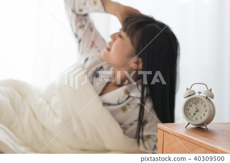 Young woman getting up with an alarm clock 40309500