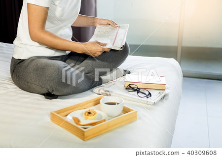 Woman reading book or newspaper and drinking coffee breakfast on 40309608