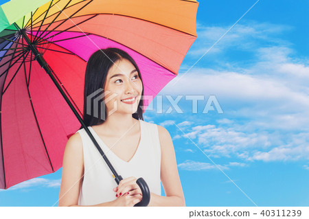 Young woman holding umbrella on blue sky Young woman holding umbrella on blue sky 40311239