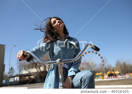 Stylish young woman riding a bicycle. 40316105