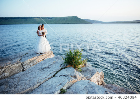beautiful gorgeous blonde bride and stylish groom on rocks beautiful gorgeous blonde bride and stylish groom on rocks 40324084