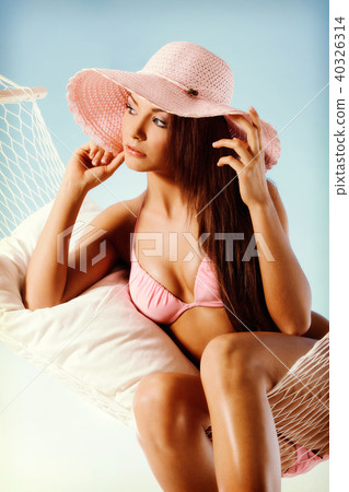 Beautiful woman in bikini relaxing in a hammock Beautiful woman in bikini relaxing in a hammock 40326314