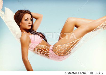 Beautiful woman in bikini relaxing in a hammock 40326317