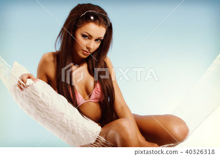 Beautiful woman in bikini relaxing in a hammock Beautiful woman in bikini relaxing in a hammock 40326318