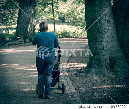 Sized mother walking with baby stroller Sized mother walking with baby stroller 40328652