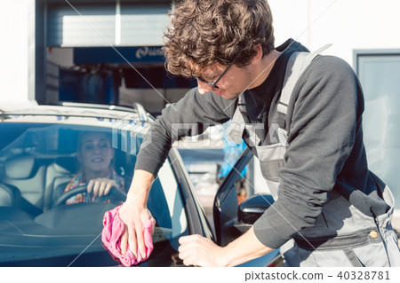 Diligent service man helping woman cleaning her car in commercial wash Diligent service man helping woman cleaning her car in commercial wash 40328781