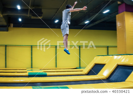 trampoline jumper performs acrobatic exercises on the trampoline trampoline jumper performs acrobatic exercises on the trampoline 40330421