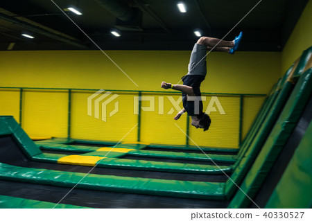 trampoline jumper performs acrobatic exercises on the trampoline trampoline jumper performs acrobatic exercises on the trampoline 40330527
