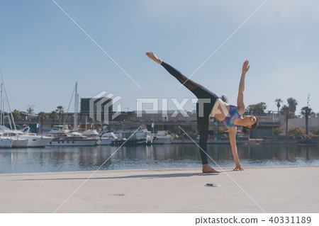 Fitness woman doing yoga urban practice outdoors. Healthy young girl practising yoga on seaside 40331189