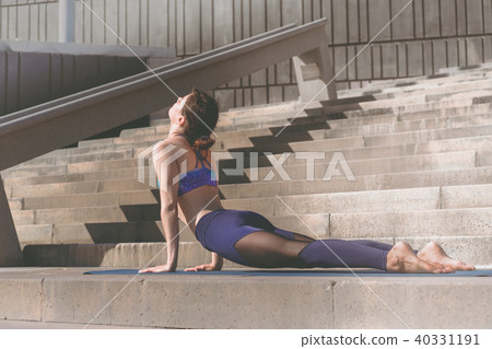 Fitness woman doing yoga urban practice outdoors. Healthy young girl practising yoga on seaside Fitness woman doing yoga urban practice outdoors. Healthy young girl practising yoga on seaside 40331191