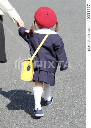 Toddler with 3-year-old in kindergarten uniform holding hands with mother (rear view) 40331317