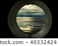 Ship window or porthole view with a relaxing seascape and dark grey clouds 40332424