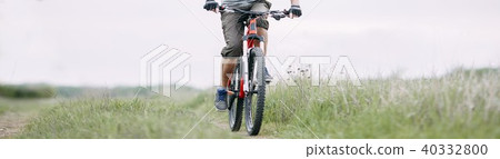 Tourist traveling riding a bike along summer field Tourist traveling riding a bike along summer field 40332800