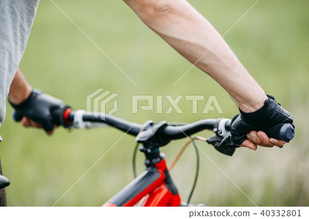 Two male hands in gloves holding bicycle handlebar Two male hands in gloves holding bicycle handlebar 40332801