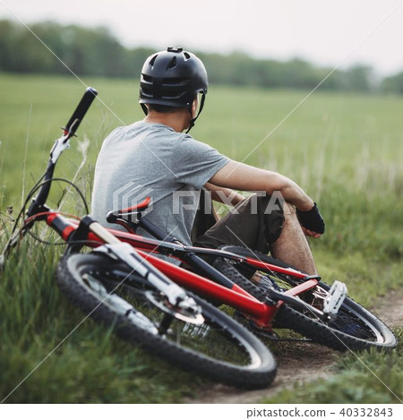 Man resting sitting at the roadside with bicycle Man resting sitting at the roadside with bicycle 40332843