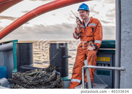 Marine Deck Officer or Chief mate on deck of ship with VHF radio 40333634