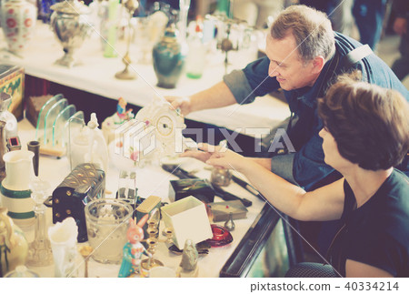 Mature tourists study the range of flea market 40334214