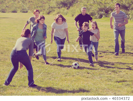 Smiling males and females kicking the ball Smiling males and females kicking the ball 40334372