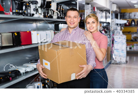 Couple with packed purchases in household appliances section in shop 40334385