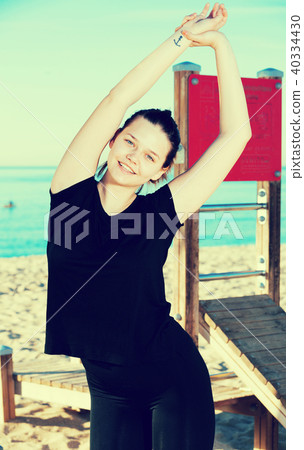 Female in black T-shirt is practicing stretching Female in black T-shirt is practicing stretching 40334430