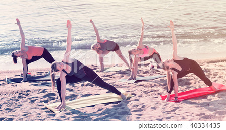 Group of young females performing yoga Group of young females performing yoga 40334435