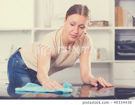 Young woman wiping table 40334436