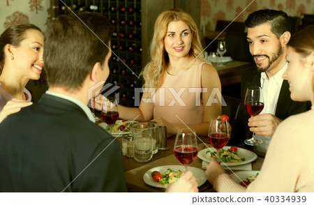 Сheerful friends having dinner and drinking red wine in restaur 40334939