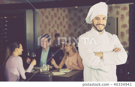 Portrait of handsome professional chef on background with restaurant guests 40334941