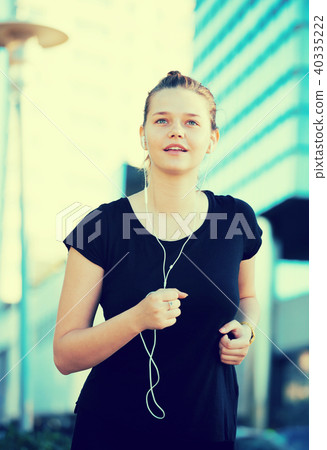 Girl enjoying morning run outdoors with music Girl enjoying morning run outdoors with music 40335222