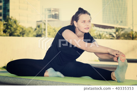 Young woman doing exercises outdoors Young woman doing exercises outdoors 40335353