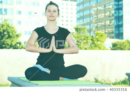Girl in lotus pose outdoors Girl in lotus pose outdoors 40335358