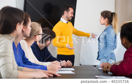 Young female student is giving answer to teacher’s question 40335726