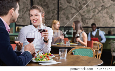 Attractive girl with boyfriend enjoying dinner with wine in cozy restaurant 40335762