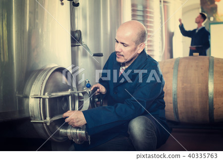 Smiling man machinery operator working in winery 40335763