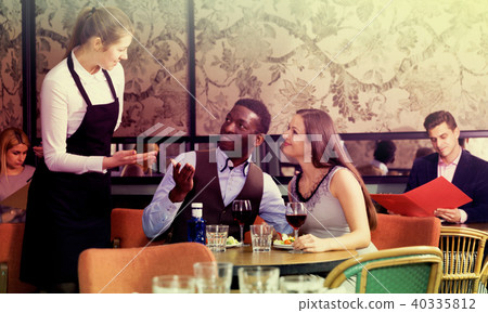 Couple talking with waitress in restaurant Couple talking with waitress in restaurant 40335812