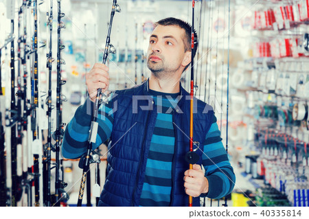 Man shopper choosing ocean fishing rod in hop Man shopper choosing ocean fishing rod in hop 40335814