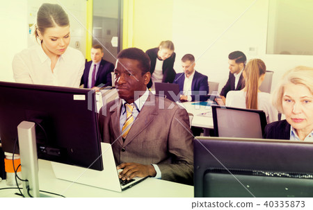 Coworkers engaged in open plan office 40335873