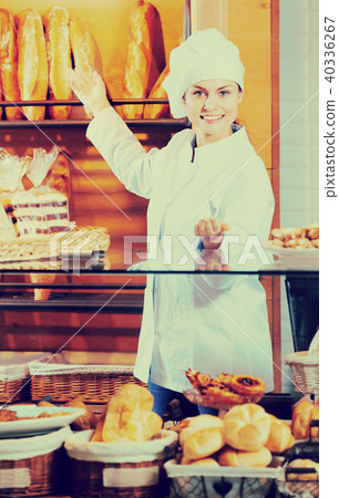 Portrait of friendly woman at bakery display 40336267