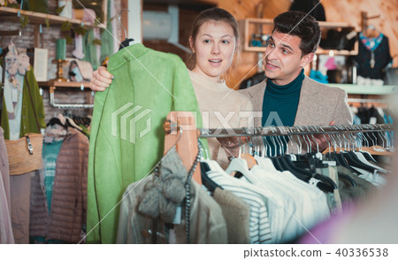 Smiling woman and man are choosing clothes and looking on green 40336538