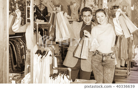 Young woman and man are standing satisfied with packadge after s Young woman and man are standing satisfied with packadge after s 40336639