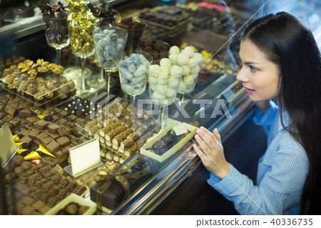Happy girl buying chocolate Happy girl buying chocolate 40336735