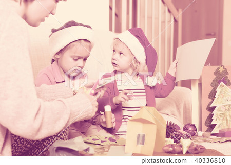 woman with two girls preparing for Christmas woman with two girls preparing for Christmas 40336810