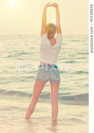 Smiling woman 25-35 years old is standing on the beach Smiling woman 25-35 years old is standing on the beach 40336829