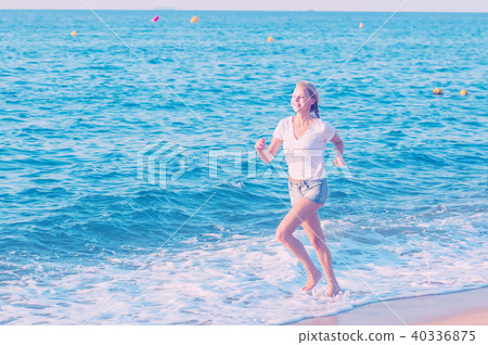Sportswoman is jogging on the beach 40336875