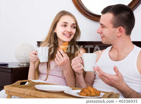 adults posing with coffee and pastry for breakfast 40336935
