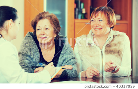 Female therapeutist consulting senior patients in clinic 40337059